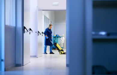 Donna che passa l'aspirapolvere in un'azienda.